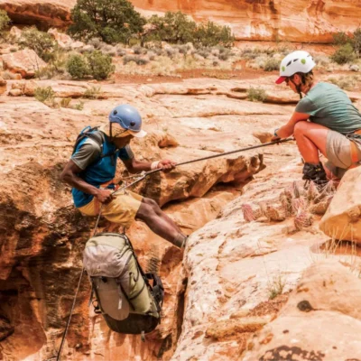 A course participant lowers themselves into a canyon while canyoneering in Utah.
