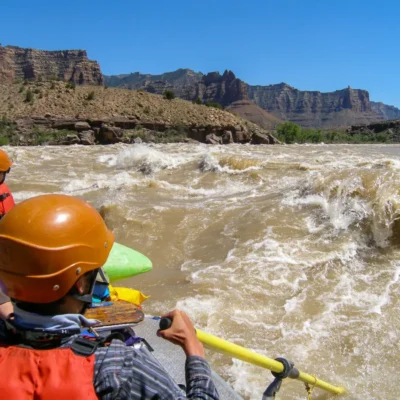 NOLS participants raft through fast-moving white water.