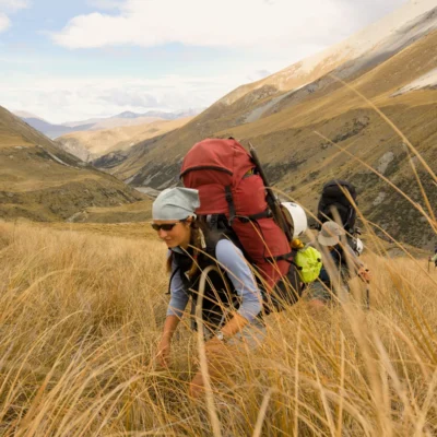 Students hiking uphill through tall grass on New Zealand's South Island.
