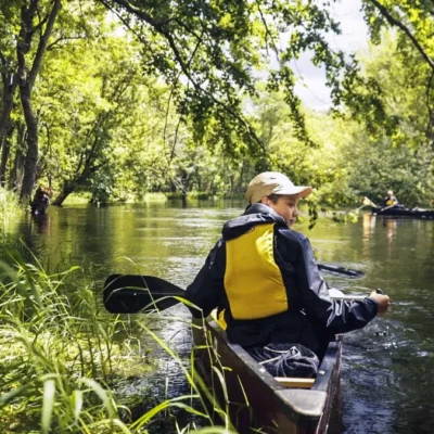 Students stop for a break while canoeing down a river in the Adirondacks.