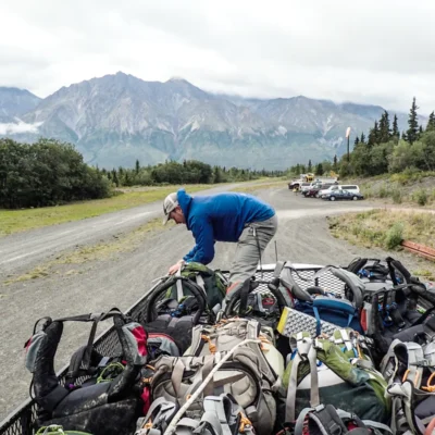 A student group loads their backpacks on the roof of a van before traveling to the Chugach Range in Alaska.