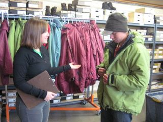 Chelsie helps a student try on their winter parka.
