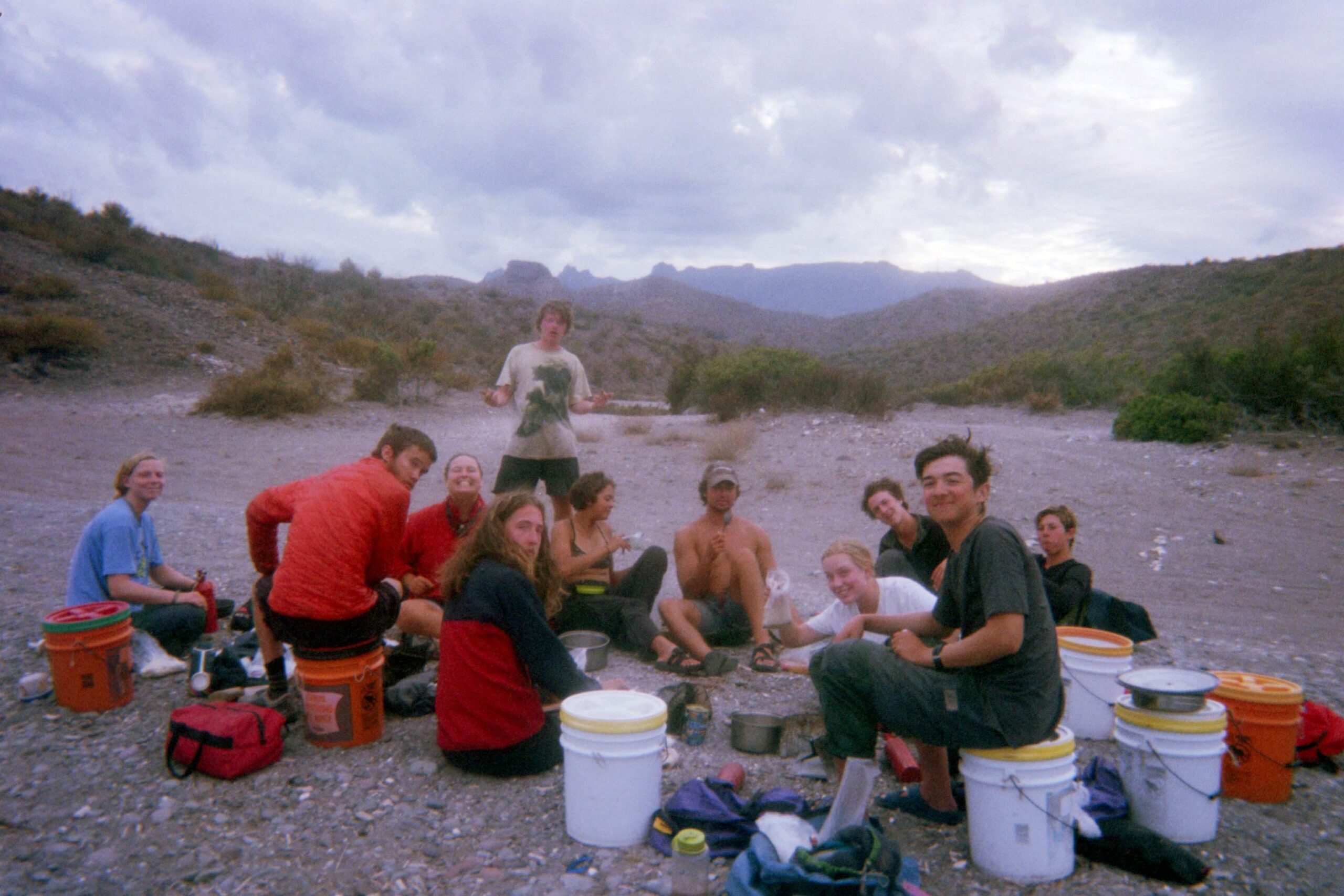 Students sit in a circle at dusk to get ready