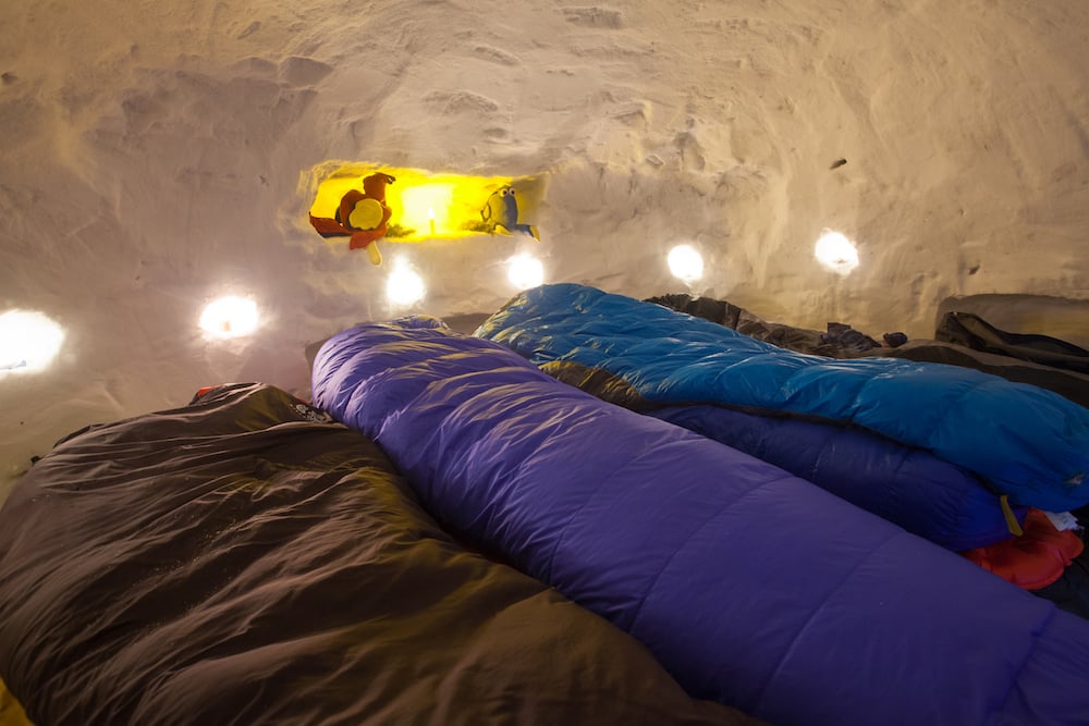 Lights twinkle on small shelves in the interior walls of a quinzhee