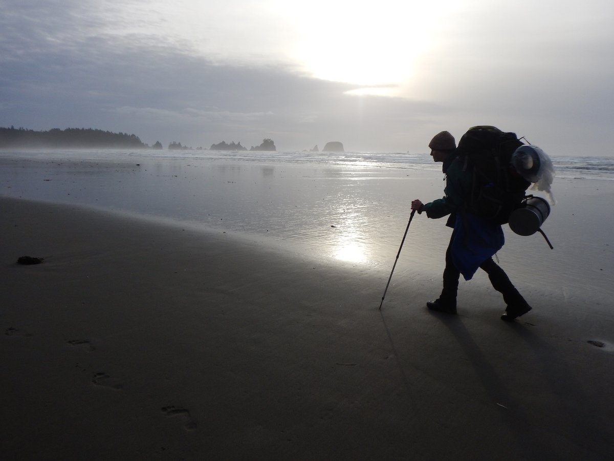 Silhouette of author hiking on a foggy coastline