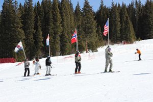 Skiers start event carrying U.S., Norwegian, and 10th Mountain Division flags.jpg