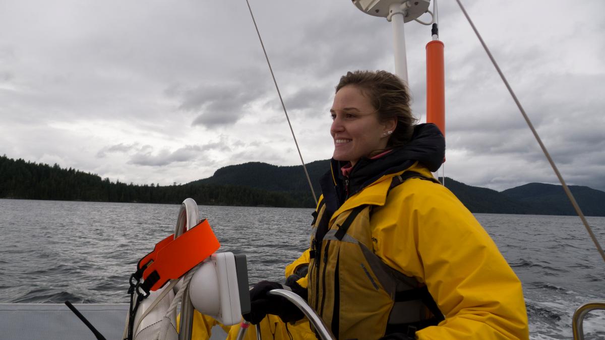 woman looking confident while steering a keelboat sailing boat in the PNW