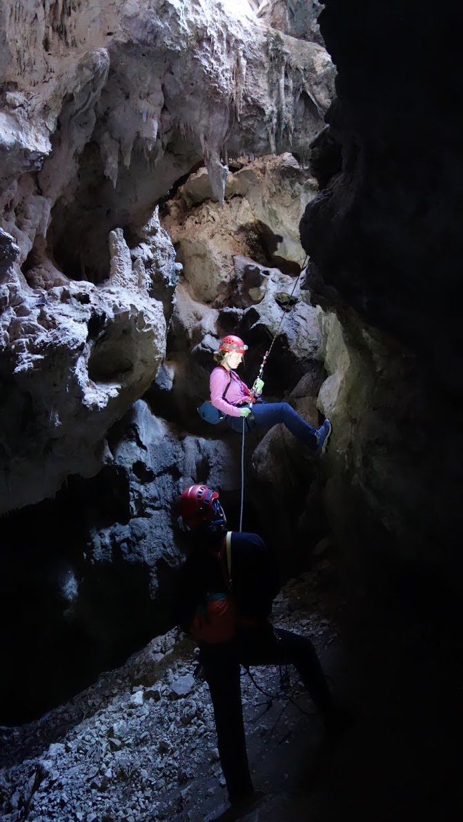 Person rappelling into a cave