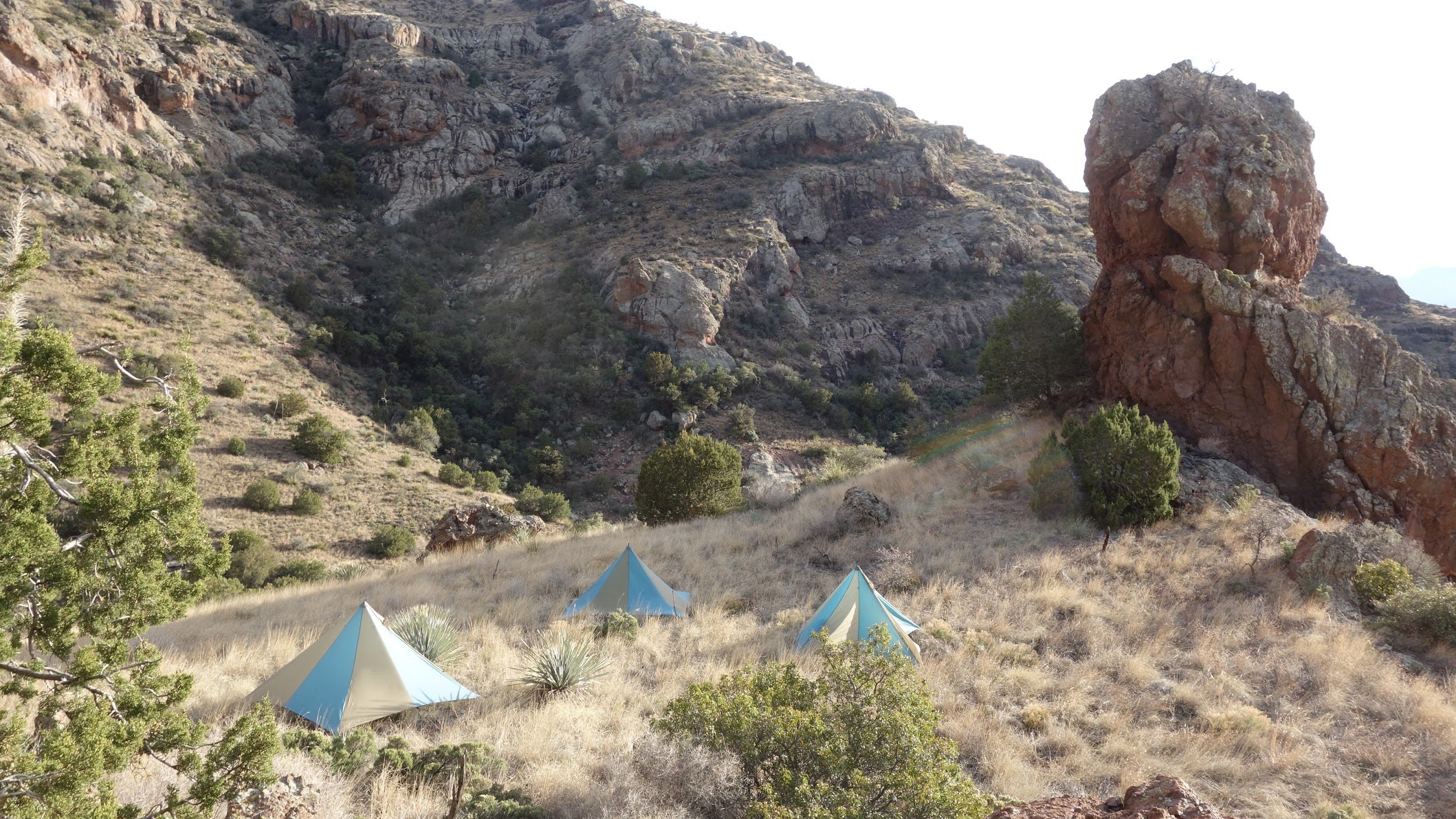 Tents in a field with rock spires