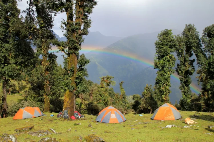 Student tents high up in the Himalayan wilderness beneath a brilliant rainbow.