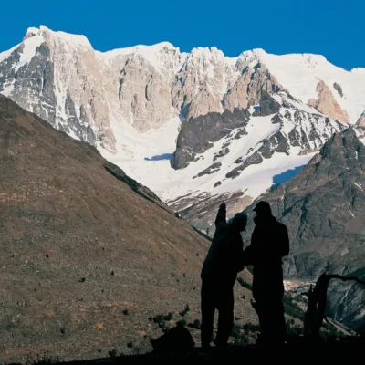 Two silhouetted students in the mountains of Patagonia practice route-finding while looking out at craggy snow-crusted peaks. Credit: Ignacio Grez