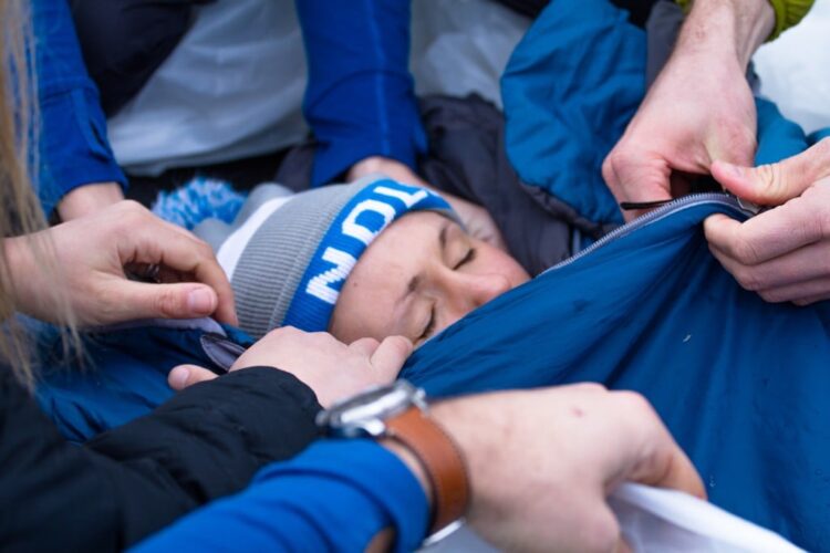 NOLS Wilderness Medicine students create a hypo wrap during a mock rescue.