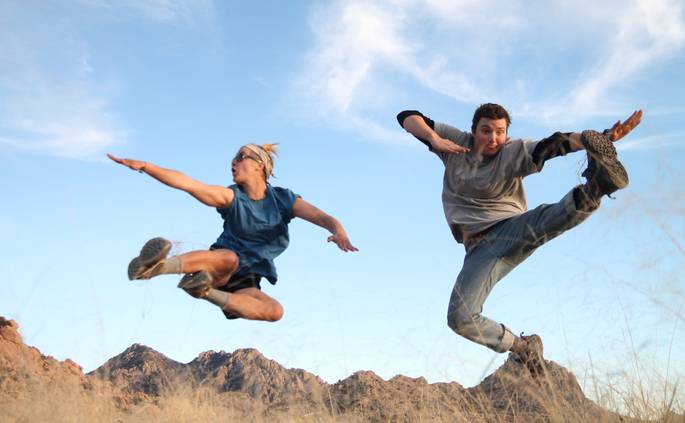 Two students jump kick for the camera in the Coronado National Forest.