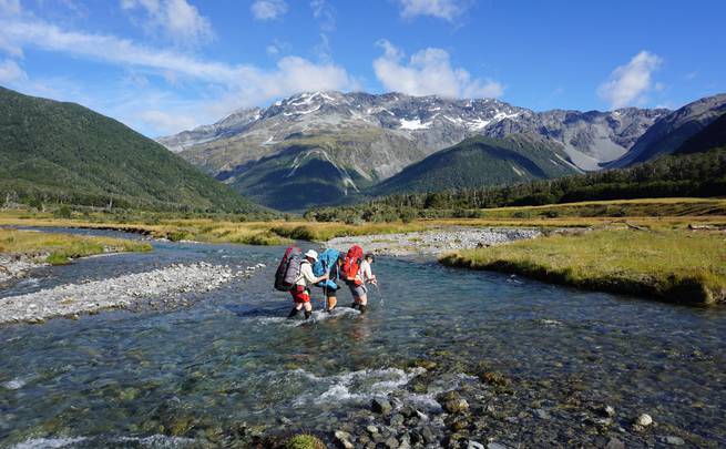 Students work together to cross a stream while backpacking in New Zealand's Nelson Lakes National Park.
