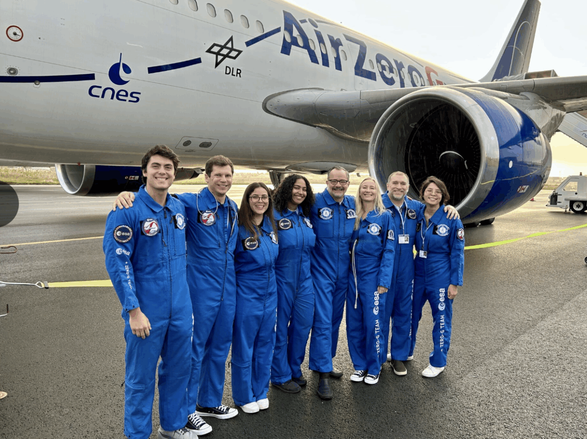 Stuart Harris, fourth from right, stands on q runway with the crew who participated in zero gravity space flights in Bordeaux, France. Behind them is their aircraft.