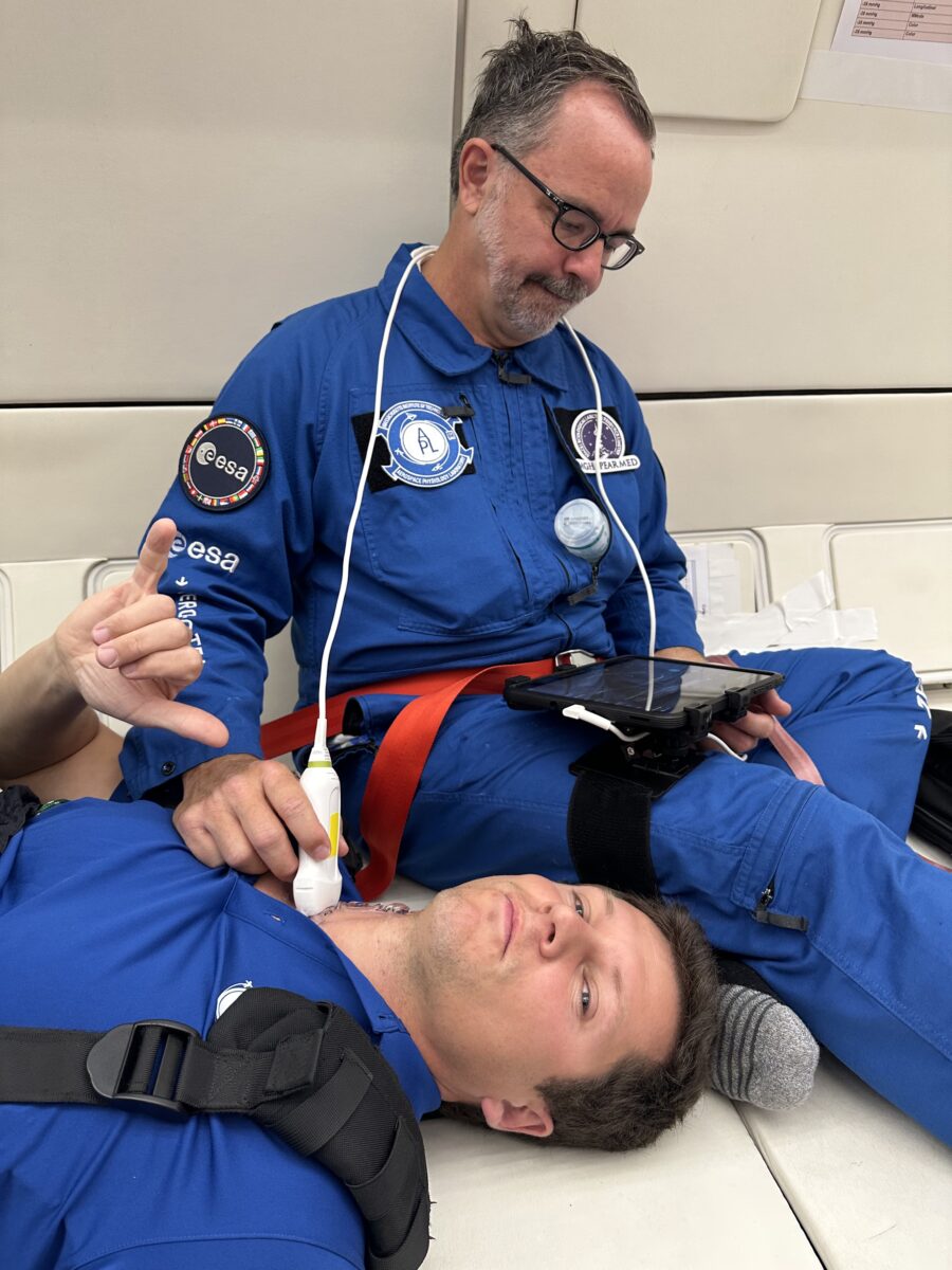 Dr. Stuart Harris, right, performs an ultrasound on a team member while in flight.