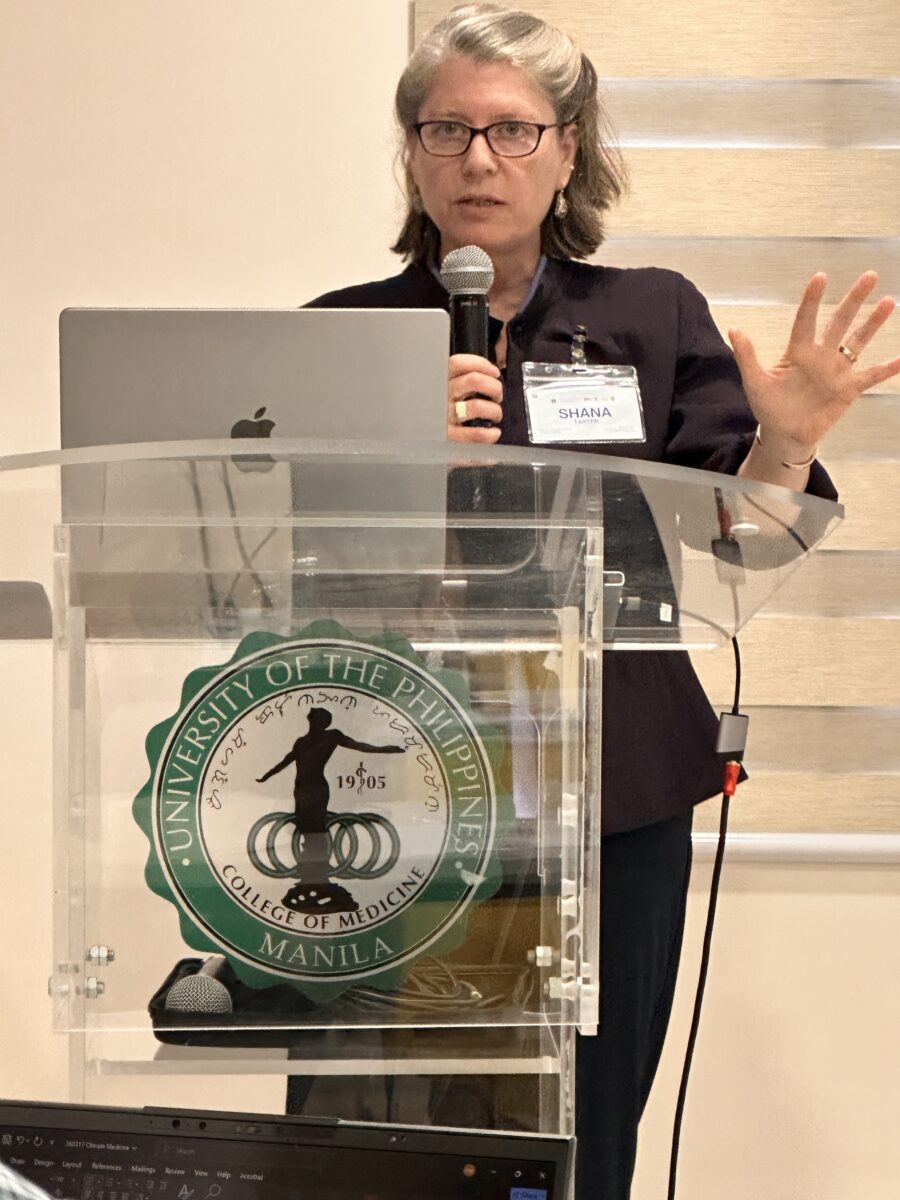 Shana Tarter st a podium presenting about the Diploma in Climate Medicine.