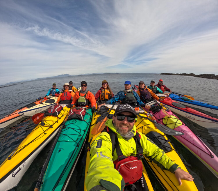Kayakers are lined up in the sea next to British Columbia's Central Coast
