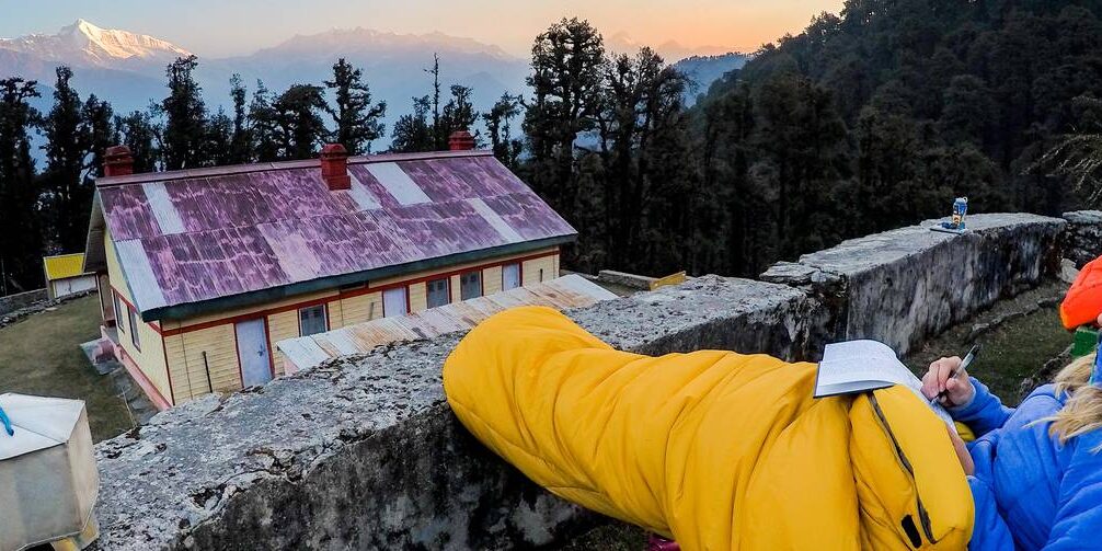 bharat_bhushan_ind-2.jpg__1400x503_q70_crop_subject_location-3124,1410_subsampling-2_upscale A student journals in their sleeping bag at sunset while looking out at India's Kumaon Himalaya.